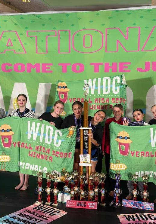 Studio celebrating Overall High Score banners and trophies at WIDC Nationals